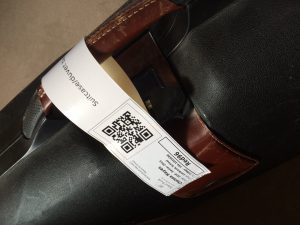 A suitcase with a QR code tracking label attached